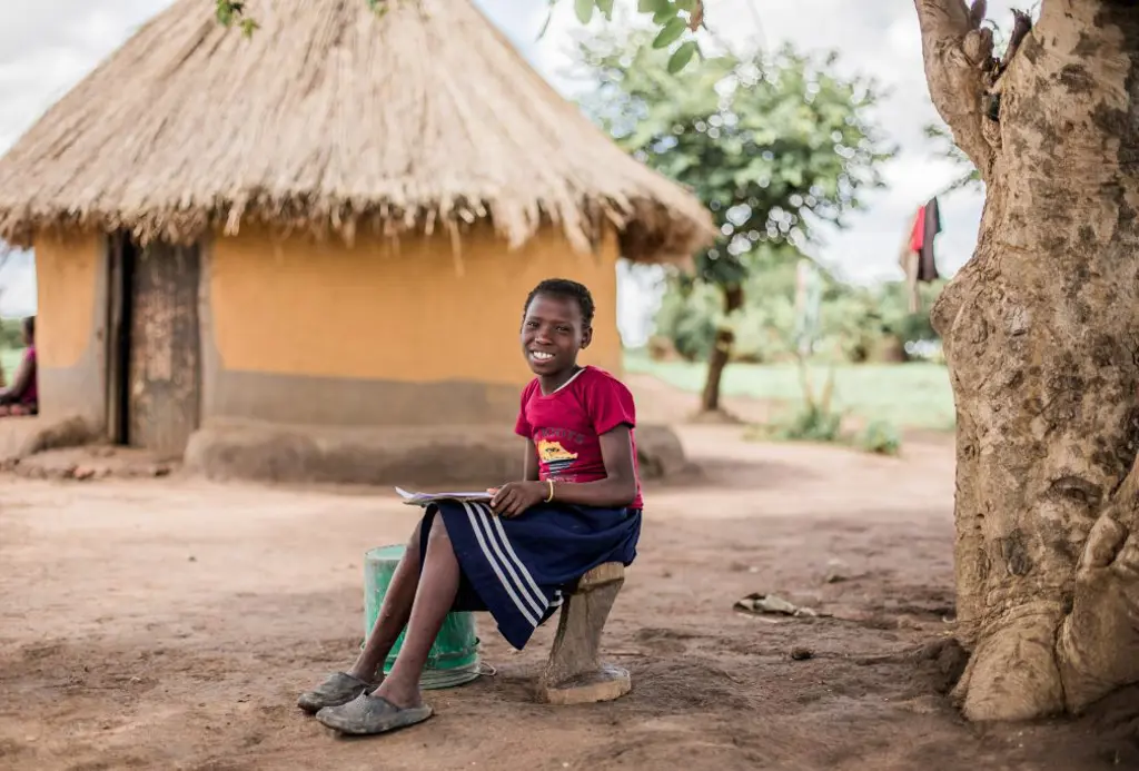 Pige i Zambia laver lektier under et træ