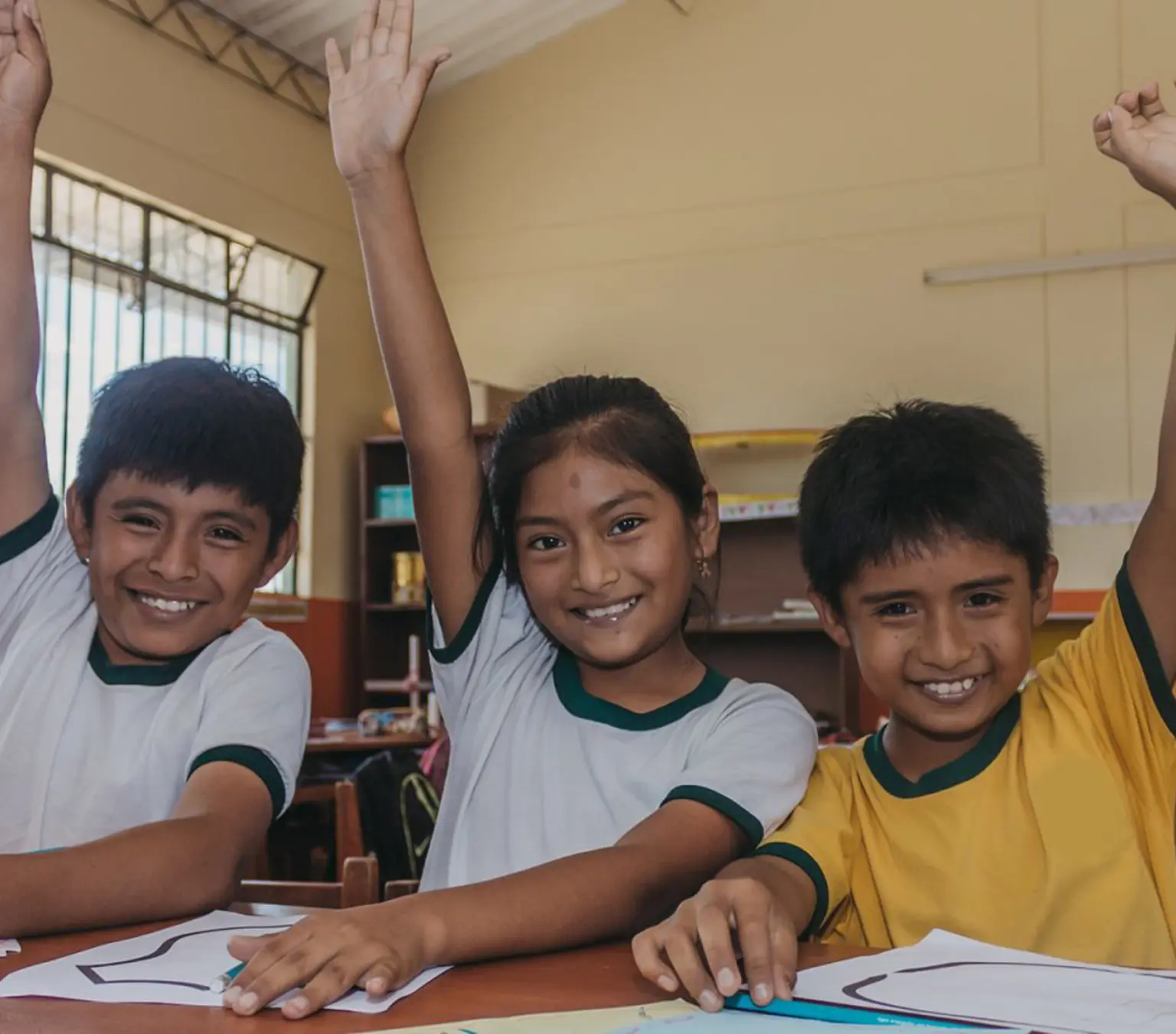 Skolebørn i Peru rækker hænderne i vejret