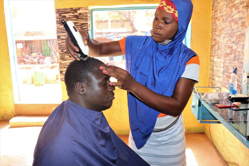 22-årige Clemence flygtede fra det nordlige Burkina Faso og har fået træning i iværksætteri. Som herrefrisør tjener hun nu mere og drømmer om egen salon. Danida-støtten gør det muligt for flere unge som hende at lære nye håndværk og starte egen forretning.